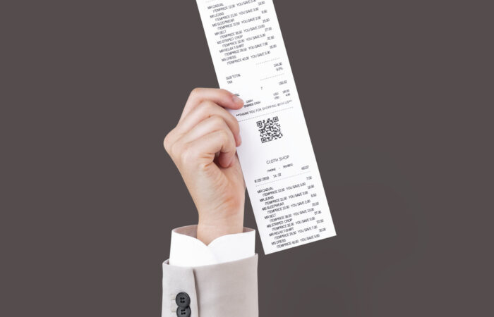 Uma mão segurando uma nota fiscal, ilustrando o conteúdo sobre chave de acesso nota fiscal.