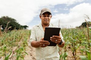 produtor em plantação usando tablet para abrir CNPJ rural