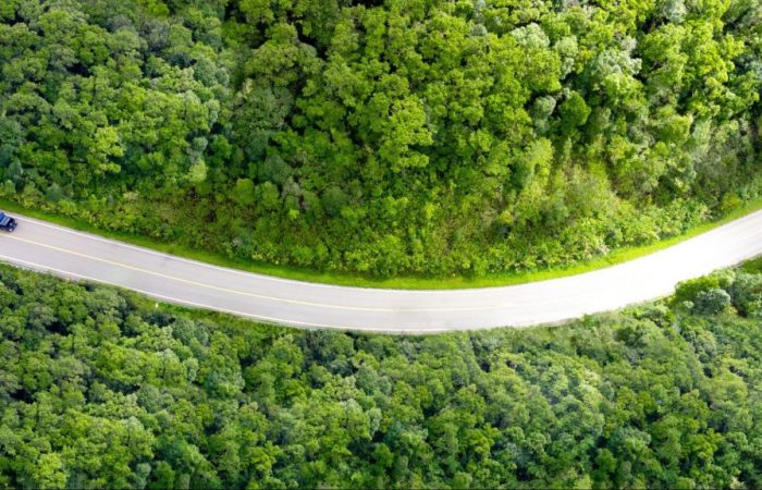 Vista de cima de caminhão de transportes em rodovia, parte essencial da cadeia de suprimentos.