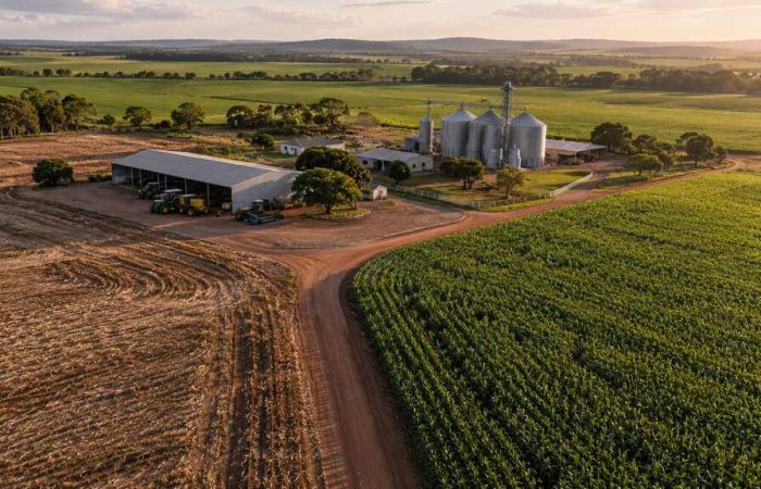 Vista aérea de fazenda com lavouras, galpões e silos, representando o patrimônio na recuperação judicial do produtor rural.